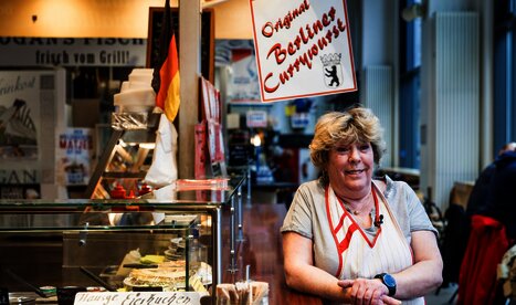 Eine Frau steht vor einer Imbussbude